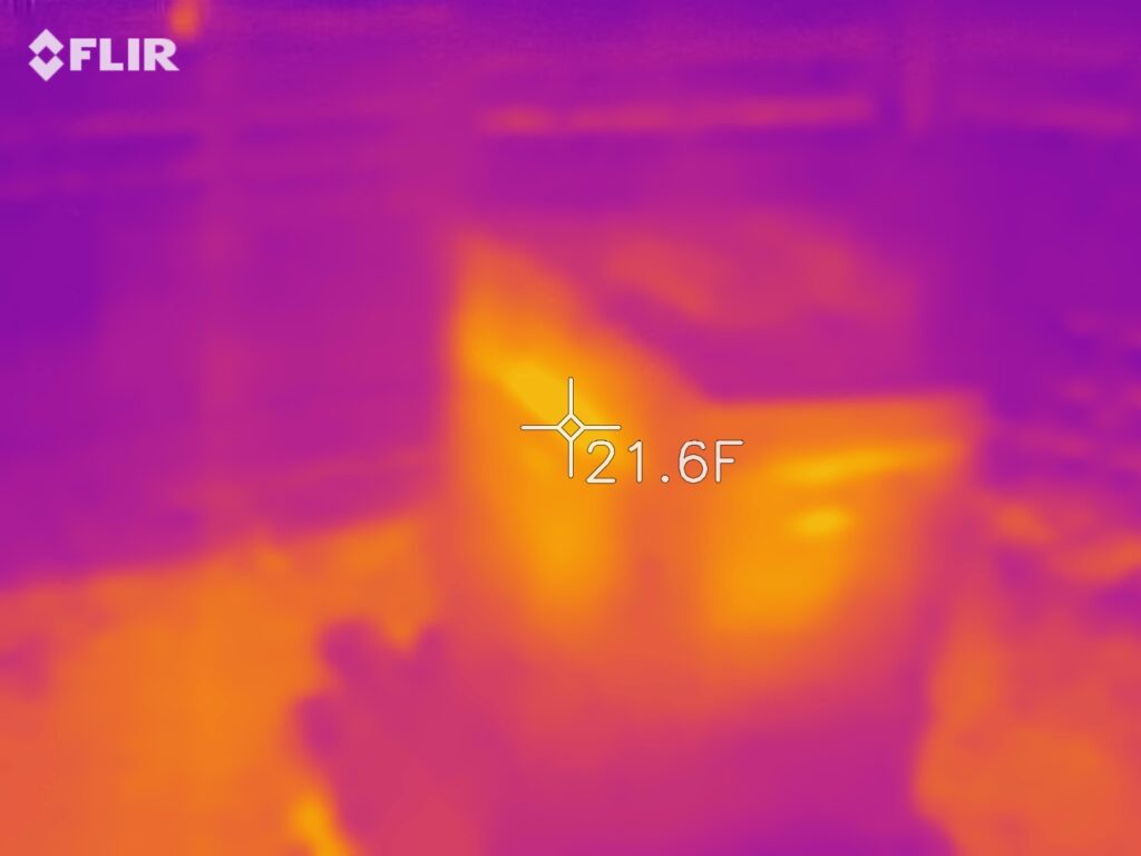 FLIR image of a hive. The glowing center indicates warmth radiating through the wooden hive walls from the cluster of bees inside.